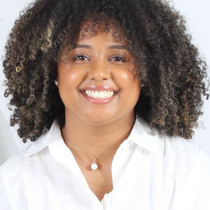Retrato de Thaís Marcelino, psicóloga, sorrindo para a câmera.